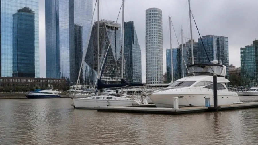 Veleros y cruceros amarrados en una dársena de Puerto Madero con la ciudad de fondo
