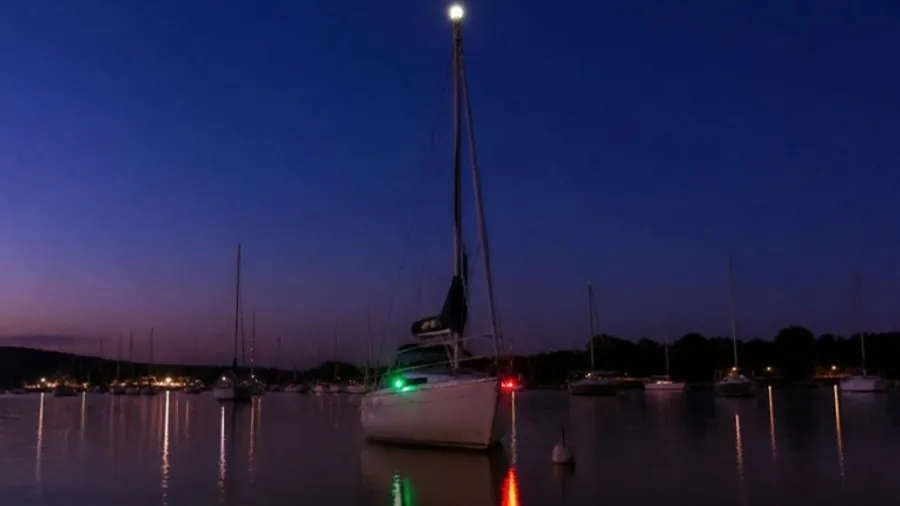 Luces de costado roja y verde encendidas en la proa de una lancha al atardecer